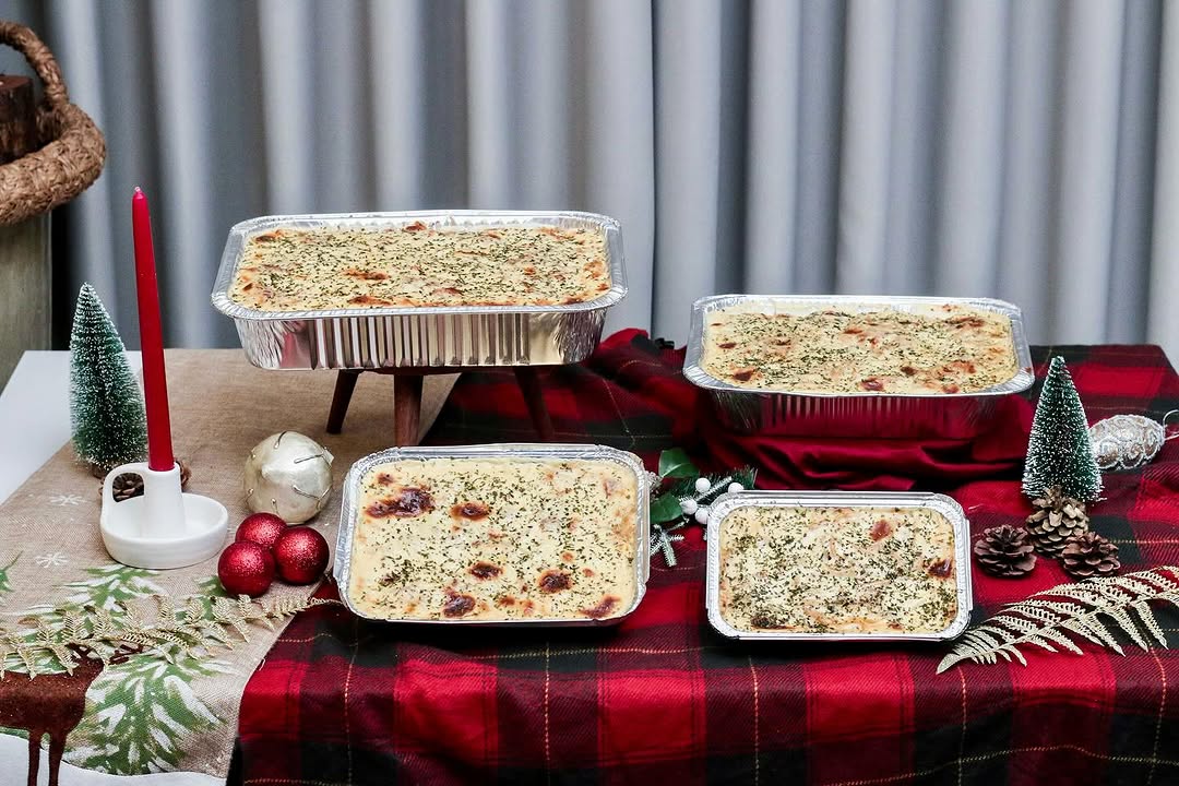 Four sizes of baked cream cheese spaghetti trays on festive table